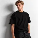 Modelo con camiseta negra junto a pared clara.webp