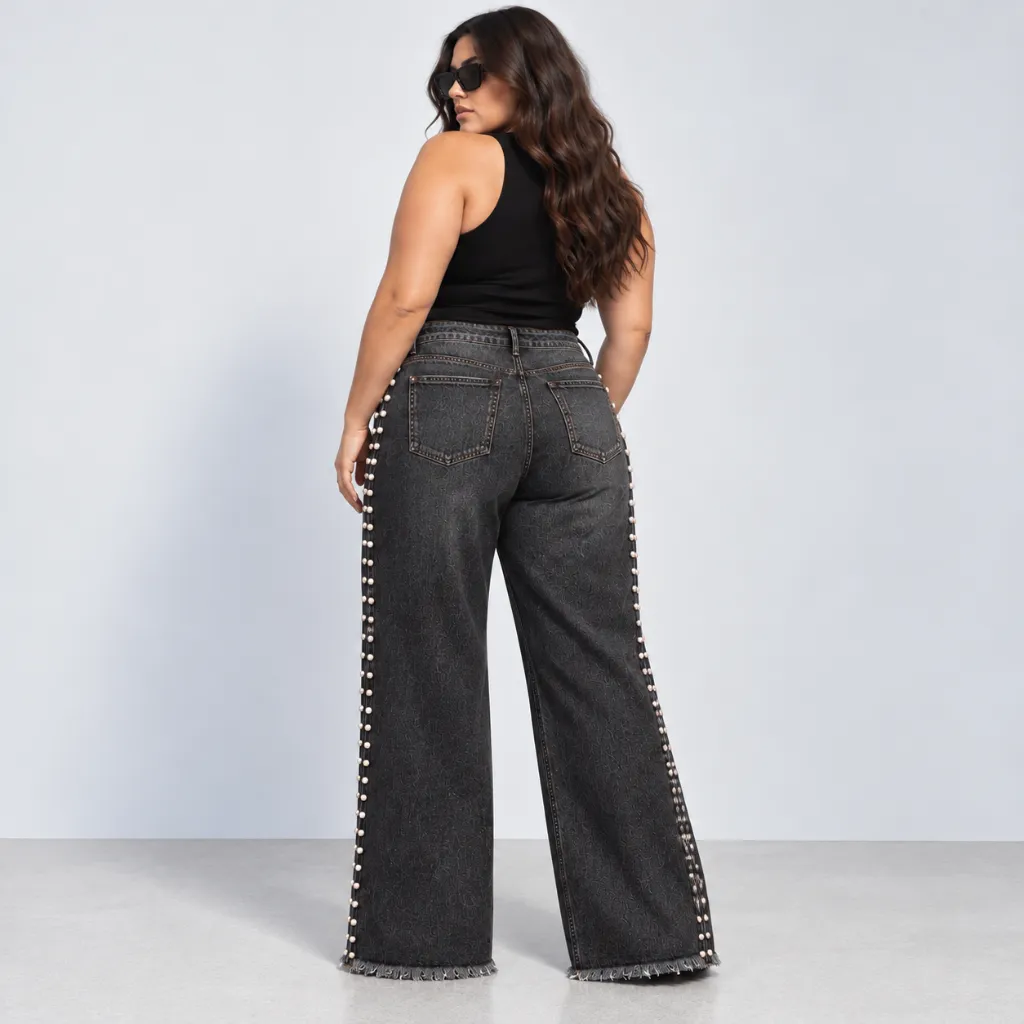 Modelo curvilínea con jeans negros tachonados.webp